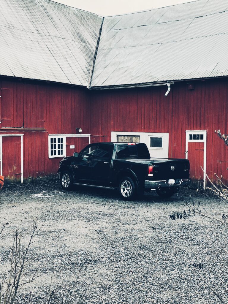 Svart Dodge Ram framför en röd ladugård